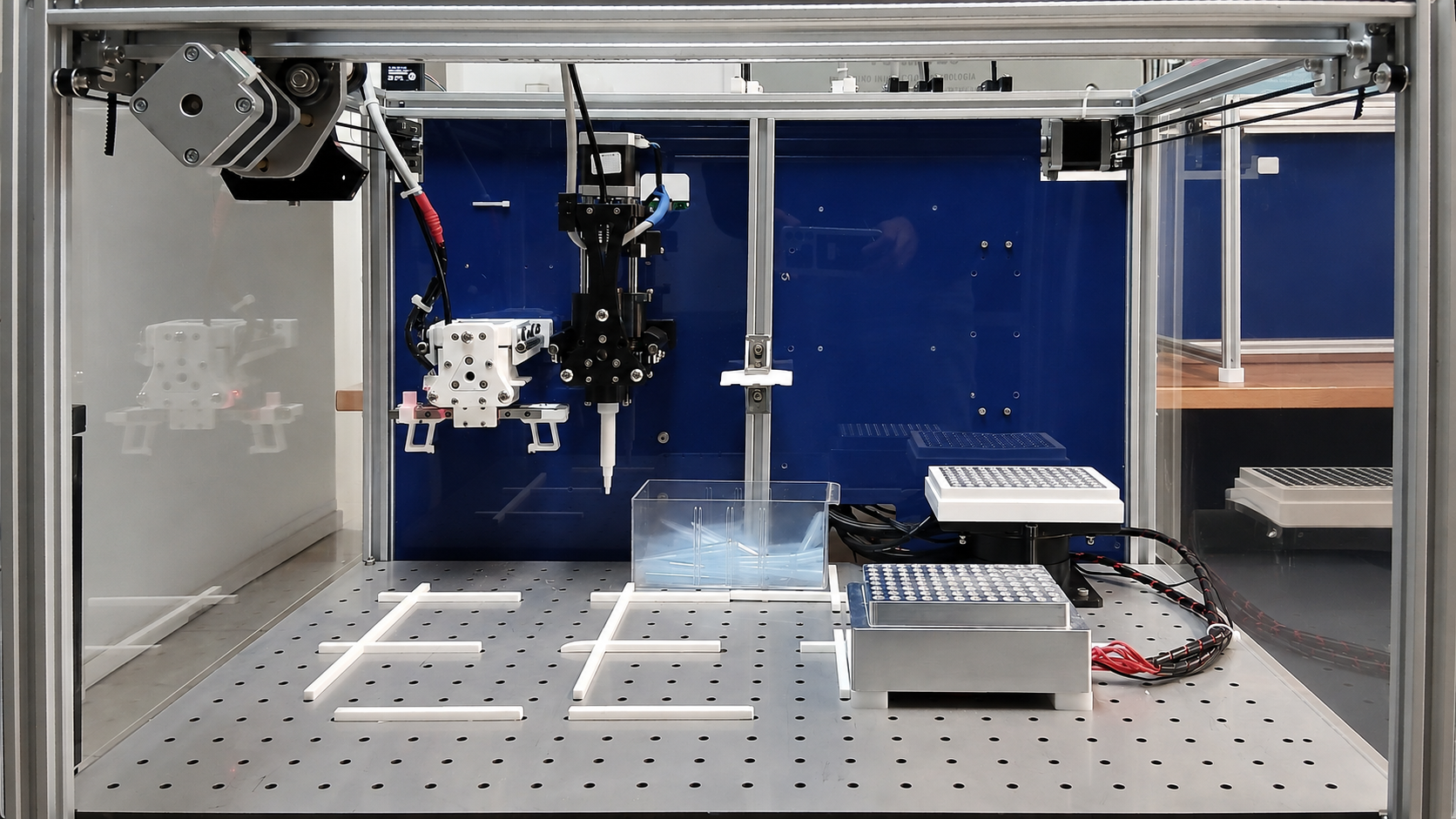 OLA laboratory robot with pipette and gripper tools over a modular work surface
